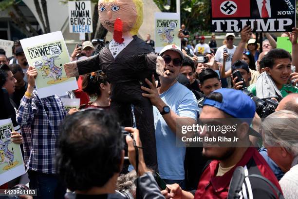 Protestors of US Republican Presidential candidate Donald Trump display signs outside the Anaheim Convention Center as Presidential candidate Trump...