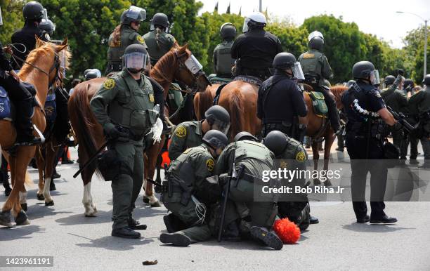 An individual wearing a clown mask is arrested by law enforcement officers after failing to disperse the area after a rally outside the Anaheim...