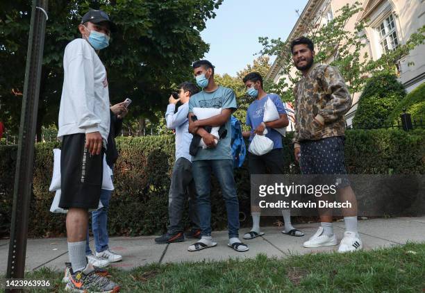 Migrants from Central and South America wait near the residence of US Vice President Kamala Harris after being dropped off on September 15, 2022 in...