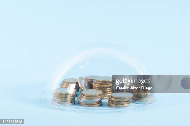 concept of savings protection. a capsule protects the coins from the outside. although in times of inflation they will lose a lot of value. - sicherung stock-fotos und bilder