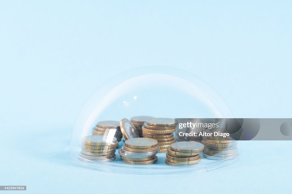 Concept of savings protection. A capsule protects the coins from the outside. Although in times of inflation they will lose a lot of value.