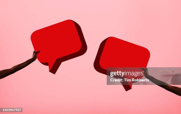 arms holding two speech bubbles - speech bubbles stock pictures, royalty-free photos & images