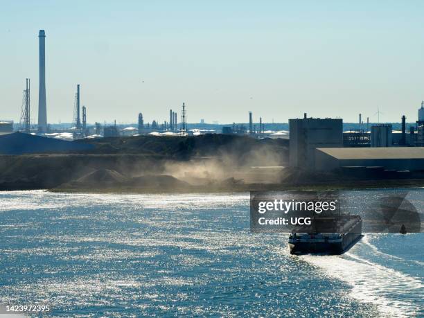 Freighter heading into Rotterdam, past serious industrial pollution, the Netherlands.