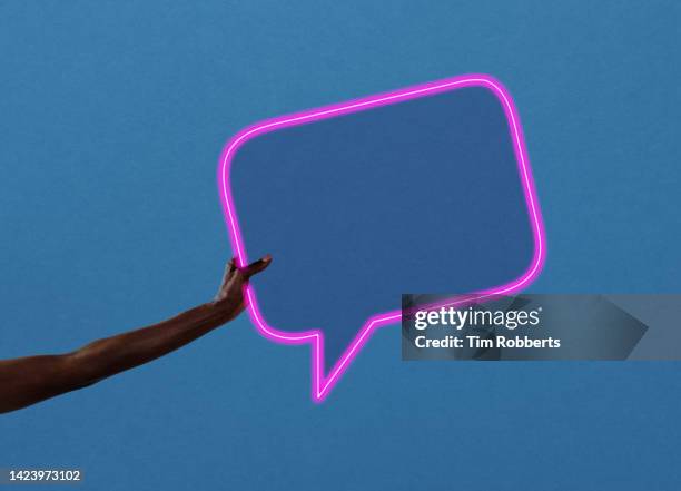 woman holding neon speech bubble - greeting stock-fotos und bilder