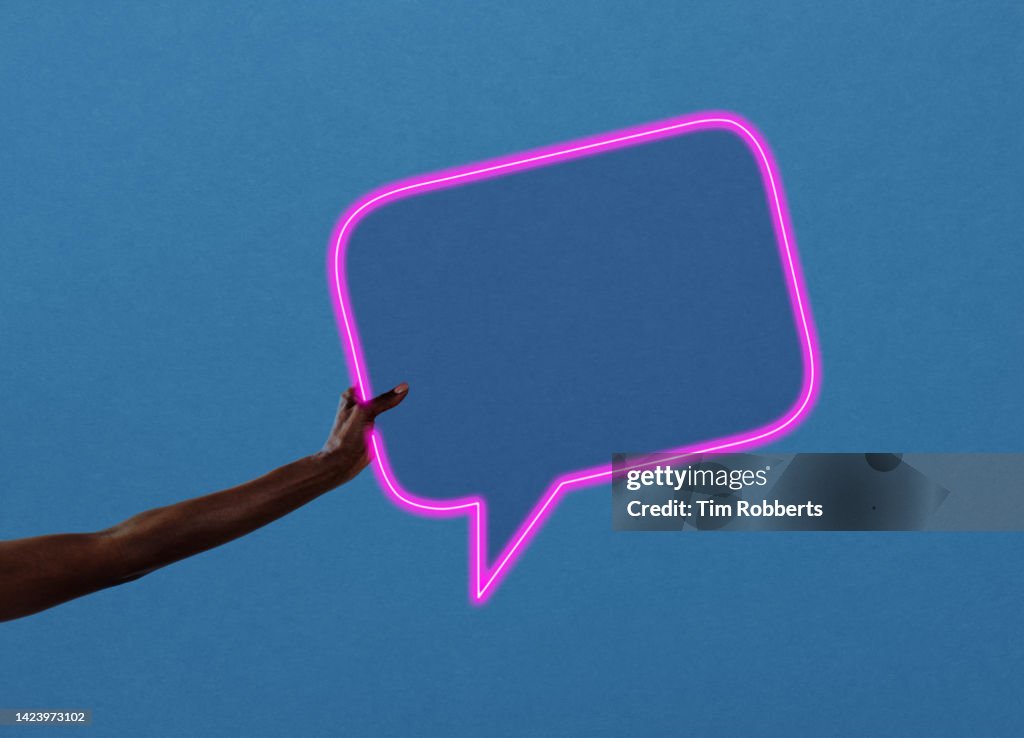 Woman holding neon speech bubble