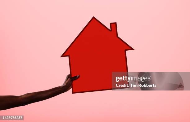 arm holding house illustration - cartoon house stock-fotos und bilder