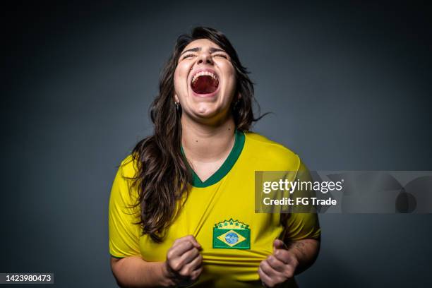 brasilianischer jungfan feiert auf gelber uniform - faces of a nation stock-fotos und bilder