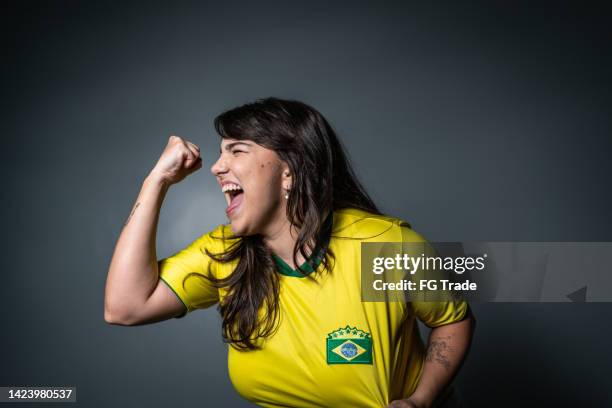 brasilianischer jungfan feiert auf gelber uniform - soccer uniform stock-fotos und bilder