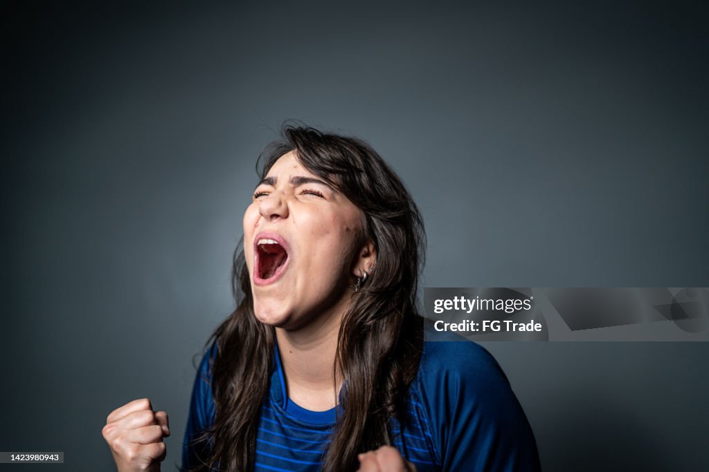 Jovem fã comemorando em uniforme azul