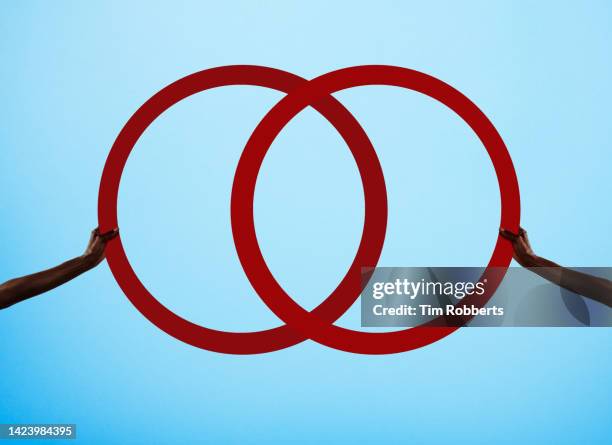 two arms holding illustrated rings - venn diagram imagens e fotografias de stock