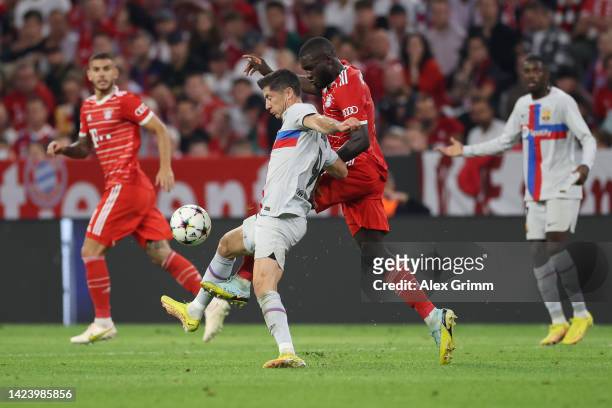 Robert Lewandowski of FC Barcelona is challenged by Dayot Upamecano of Bayern Muenchen during the UEFA Champions League group C match between FC...