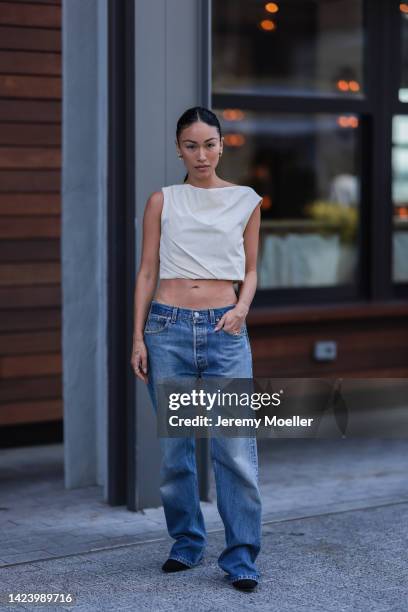 Stephanie Suganami Shepherd is seen wearing a creme beige sleeveless cropped top, gold earrings and blue denim Levi's baggy jeans, outside Jason Wu...