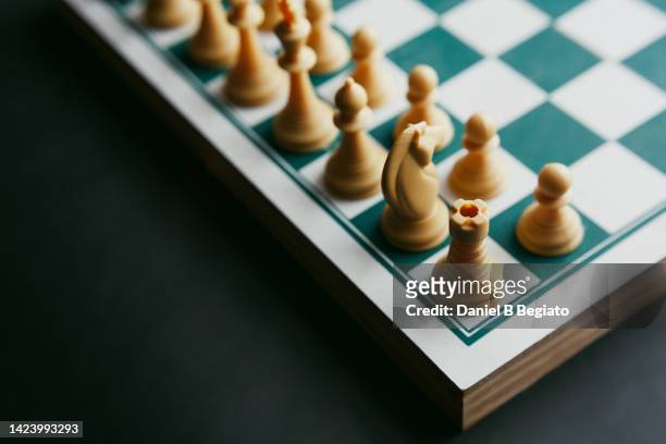 cropped view of a chess board and chess pieces, on a dark background. - chess board without stock-fotos und bilder