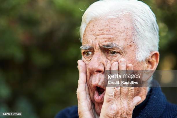 elderly man with white hair looks shocked, scared and horrified with hands to his face and mouth open - crazy white hair stock pictures, royalty-free photos & images