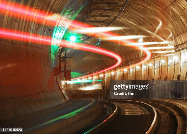 railway tunnel with fast train and green signal lamp - underground train stock pictures, royalty-free photos & images