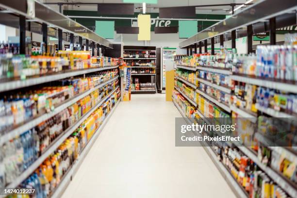 allée de supermarché avec des étagères pleines de produits - empty supermarket shelves photos et images de collection