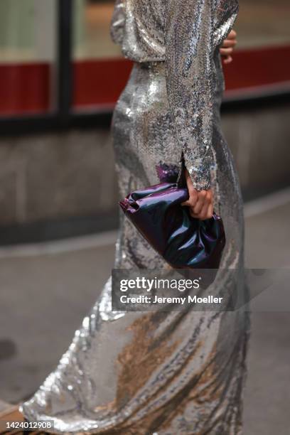 Fashion Week Guest seen wearing a silver shiny pailettes dress and a Bottega Veneta pouch during New York Fashion Week on September 13, 2022 in New...