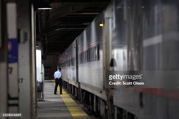 Amtrak conductor Kurt Pipenhagen helps to boards passengers for a train to Milwaukee at Union Station on September 15, 2022 in Chicago, Illinois....