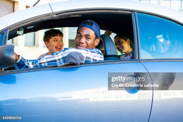 four young friends in car, travel - domestic car fotografías e imágenes de stock