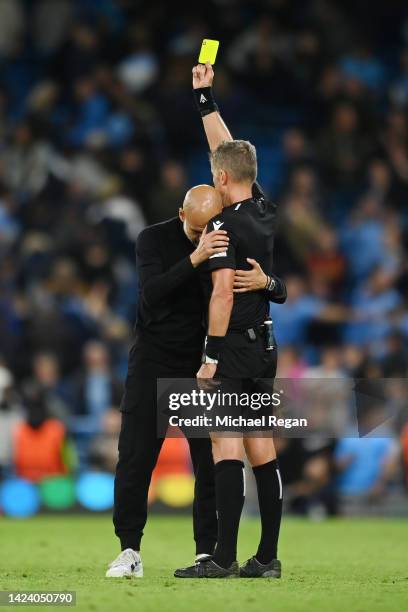Pep Guardiola, Manager of Manchester City interacts with match referee Daniele Orsato after receiving a yellow card during the UEFA Champions League...