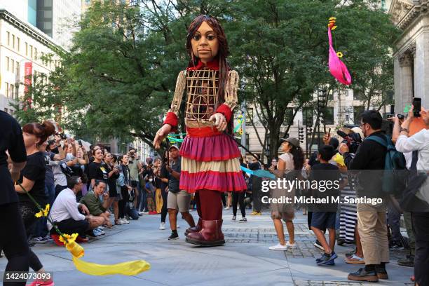 Little Amal, a 12-foot-tall puppet representing a 10-year-old Syrian refugee girl, performs with members of New Victory LabWorks at the New York...