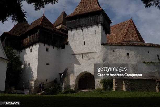 Tourists enter the Viscri fortified church on September 15, 2022 in Viscri, Romania. The village of Viscri is a UNESCO World Heritage site known for...