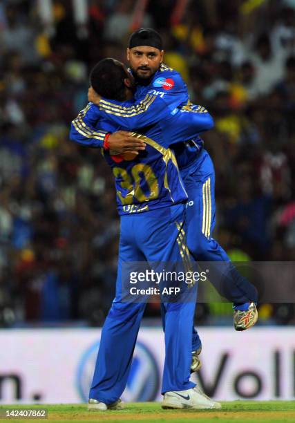 Mumbai Indians captain Harbhajan Singh leaps into the arms of fielder Pragyan Ojha as they celebrate the dismissal of unseen Chennai Super Kings...