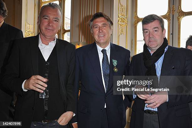 Bryan Ferry poses with Patrick Seguin and Luc Castel after being awarded Officier Des Arts Et Des Lettres at Ministere de la Culture on April 4, 2012...