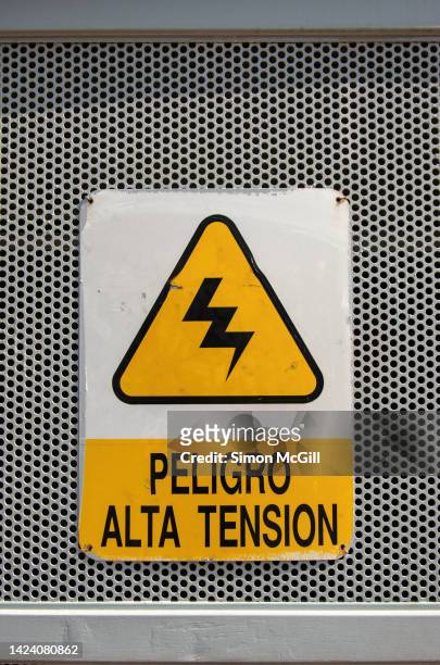 spanish-language 'peligro: alto tensión [danger: high voltage]' warning sign on a metal housing for electric equipment - alto voltaje fotografías e imágenes de stock