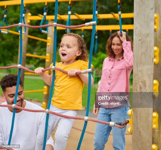 family playing on a climbing frame - climbing frame stockfoto's en -beelden