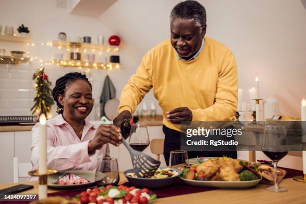 senior couple enjoying dinner for the new year - 55 year old male stockfoto's en -beelden