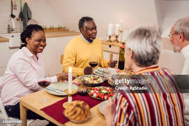 ältere freunde genießen ein abendessen am silvesterabend - 55 year old woman stock-fotos und bilder