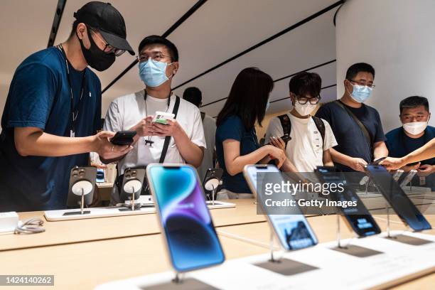 Customers look at the new iPhone14 at an Apple store on September 16,2022 in Wuhan. Hubei, China.