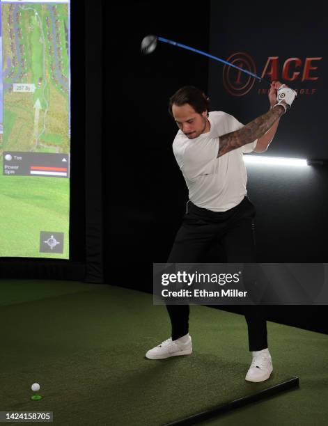 Auston Matthews of the Toronto Maple Leafs takes a swing at a golf simulator during the 2022 NHL player media tour at Encore Las Vegas on September...