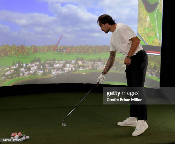Auston Matthews of the Toronto Maple Leafs prepares to take a swing at a golf simulator during the 2022 NHL player media tour at Encore Las Vegas on...