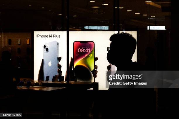 Customers line up at an Apple Store to pick up their orders of the new iPhone 14 on September 16, 2022 in Wuhan. Hubei, China.
