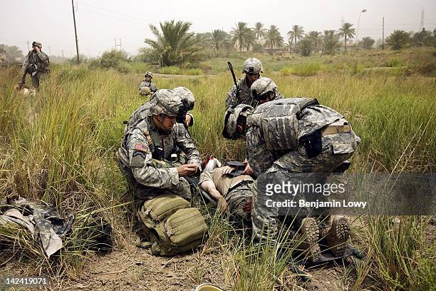 Medics hover over the shattered form of LTC Mark Odom after his vehicle was destroyed by a command detonated IED on August 4, 2007 in Hawr Rajab,...