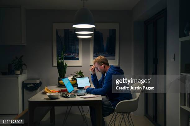 a stressed mature man goes through his home finances at the dining table - debt 個照片及圖片檔