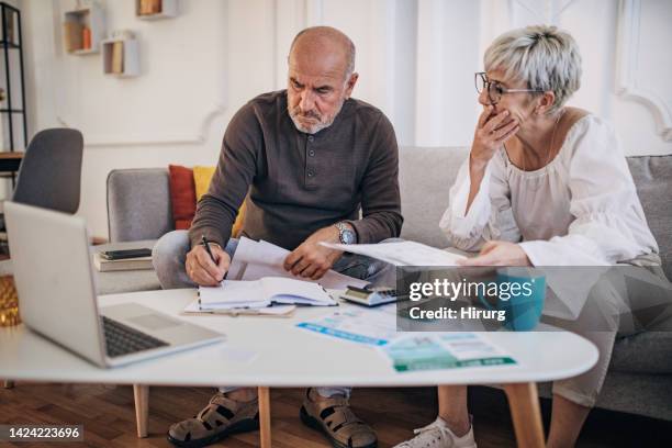couple calculating bills and taxes and home and trying to organise to pay them - energy bill stockfoto's en -beelden