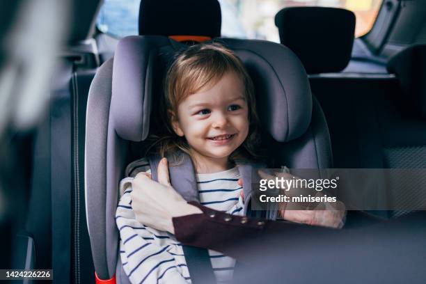 close up shot of a beautiful cheerful little girl happy to go for a car ride - happy toddler stockfoto's en -beelden