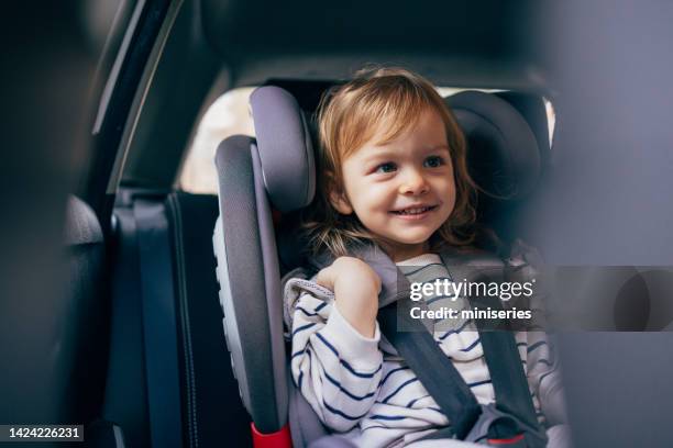 retrato de una niña feliz sentada en un asiento de seguridad para el automóvil lista para dar un paseo - buckle fotografías e imágenes de stock