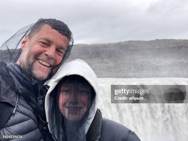 padre e figlio selfie felice indossando reti per la testa protezione contro i moscerini chironomidi alla potente cascata - dettifoss waterfall foto e immagini stock