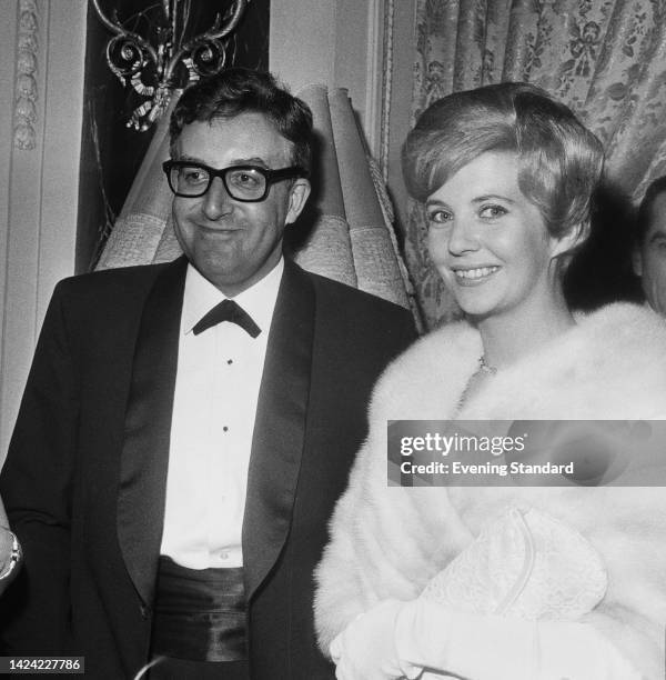 British actor and comedian Peter Sellers , wearing a tuxedo with a continental tie, alongside his wife, Australian actress Anne Howe, wearing a white...