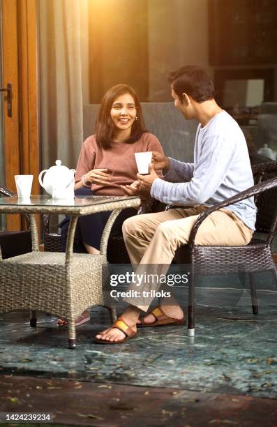 cheerful couple having coffee outdoors - indian couple tea stock pictures, royalty-free photos & images