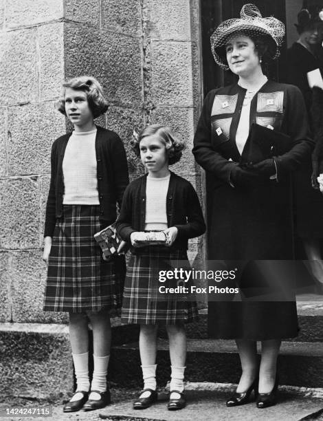 Queen Elizabeth and her daughters, Princess Elizabeth and Princess Margaret, leaving a church bazaar held at Crathie Kirk near Balmoral,...