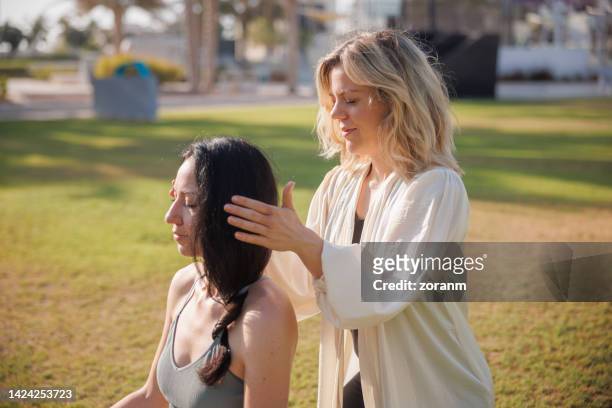 healing head with alternative reiki treatment in public park in abu dhabi - energy healing stock pictures, royalty-free photos & images