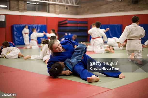 two girls in a judo lesson. - arts martiaux photos et images de collection