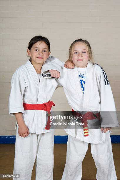 two girls in  judo kit posing for the camera. - judo kids stock pictures, royalty-free photos & images