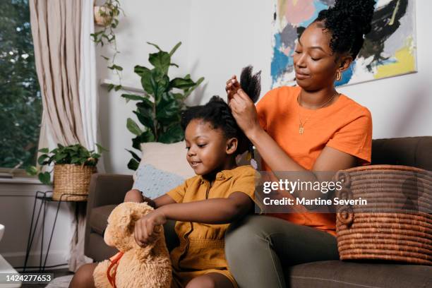 young black girl gets her hair braided by mother - showus hair stock pictures, royalty-free photos & images