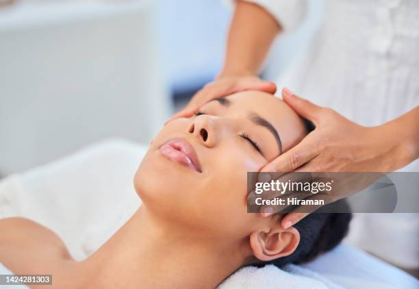 la donna riceve un massaggio viso o viso presso la spa dal terapista di bellezza presso il salone di bellezza per la salute della pelle e il trattamento di benessere. donna o ragazza nera in relax e cura della pelle terapia di bellezza massaggiatrice studi - head massage foto e immagini stock